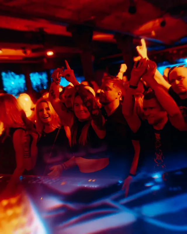 Świętująca publiczność przy konsolecie DJ-a w Słodowni